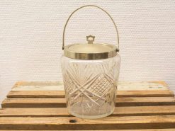 Elegant vintage glass ice bucket with intricate patterns and polished metal lid.