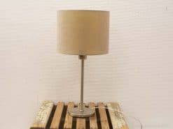 Modern vintage table lamp with sleek metallic base and cozy fabric shade on rustic wood.