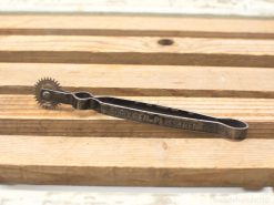 Vintage tool with serrated wheel, aged patina, perfect for craftsmanship and collectors.