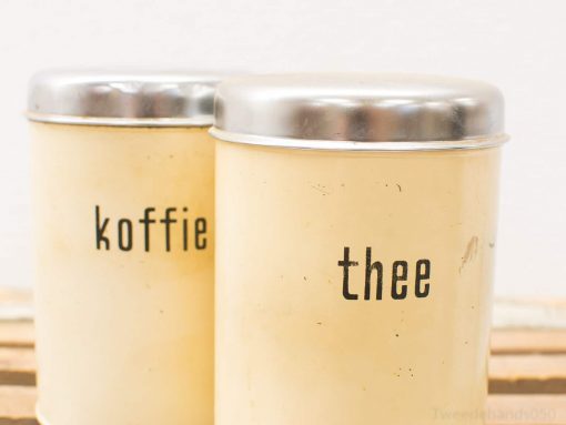 Charming vintage koffie and thee canisters for a nostalgic kitchen experience.