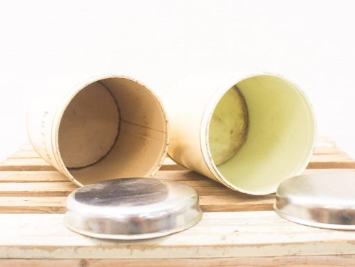 Charming vintage cylindrical containers with metallic lids, perfect for rustic home decor.