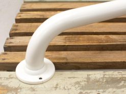 Stylish white metal handrail on weathered wooden boards, blending safety with rustic charm.