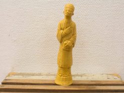 Intricately carved yellow wooden statue, showcasing cultural craftsmanship and serene elegance.