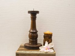 Elegant wooden candlestick and delicate flower for a cozy, inviting decor.