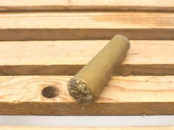 Olive green cylindrical object on rustic wooden pallet, inviting curiosity about its purpose.