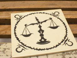 Elegant decorative tile featuring a justice scale symbolizing fairness and equality.