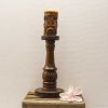 Elegant wooden candle holder with intricate carvings and a decorative floral accent.