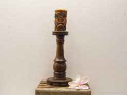 Elegant wooden candle holder with intricate carvings and a decorative floral accent.