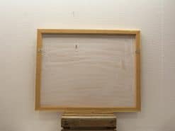 Simple wooden frame ready for displaying a landscape painting in a creative space.