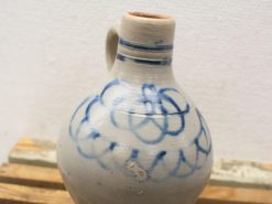 Traditional pottery jug with elegant blue designs and functional handle, perfect for decor.