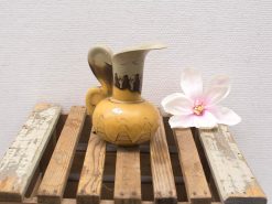 Charming vintage yellow ceramic pitcher with faux magnolia, perfect for stylish home decor.