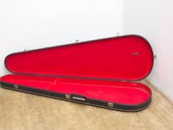 Stylish vintage guitar case in black with plush red interior for ultimate instrument protection.