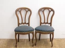 Elegant vintage teal chairs with gold accents, perfect for stylish dining and cozy conversations.