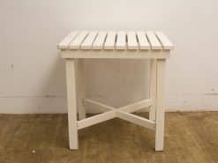 Elegant white wooden table with slatted design, perfect for versatile interior styles.