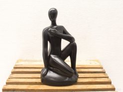 Minimalist seated figure sculpture exuding serenity and contemplation for modern art enthusiasts.