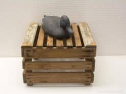 Rustic wooden crate with intricately designed decorative duck sculpture for vintage-style decor.