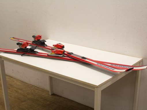 Red, black, and yellow Salomon skis with bright bindings, perfect for adventurous skiing.