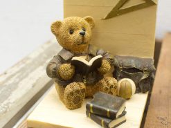 Charming vintage teddy bear reading a book in a leather jacket, evoking childhood nostalgia.