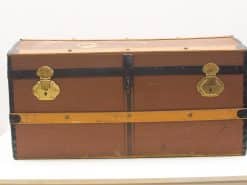 Vintage brown trunk with leather accents and brass clasps, perfect for storage or decor.