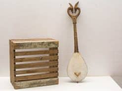 Vintage wooden lute paired with rustic crate, embodying artistry and nostalgia for music lovers.