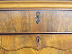 Antique wooden chest with ornate keyholes and rich craftsmanship, perfect for decor and storage.