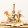 Charming vintage figurine of two children joyfully making music with a flute and violin.