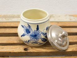 Charming vintage ceramic storage jar with blue floral design and metallic lid for practical decor.