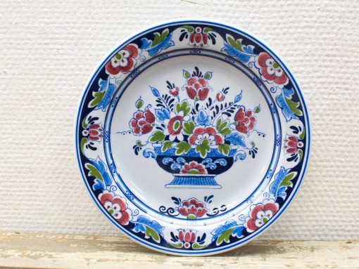 Ceramic decorative plate featuring a vibrant floral bouquet and elegant blue border.