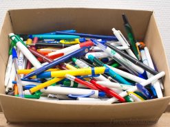 Vintage box overflowing with colorful pens, perfect for creatives and nostalgia lovers.