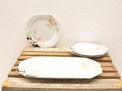 Elegant porcelain plates with floral designs on rustic wood, perfect for special occasions.