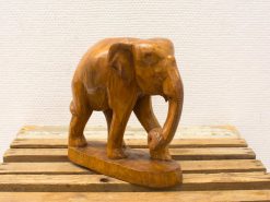 Intricately carved wooden elephant sculpture, showcasing expert craftsmanship and rich wood tones.