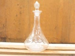 Elegant glass decanter with a detailed stopper, perfect for serving wine or water.