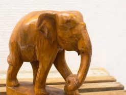 Handcrafted wooden elephant sculpture displaying intricate details and a warm, vintage charm.