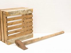 Rustic wooden crate with gardening tool, perfect for outdoor storage and gardening enthusiasts.