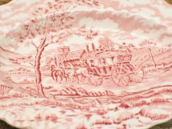 Vintage plate featuring a horse-drawn carriage in a nostalgic rural landscape with red tones.