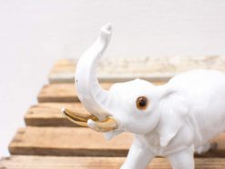 Elegant porcelain elephant figurine with gold tusks, perfect for stylish home decor.