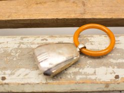 Sleek retro keychain with orange ring, blending vintage style and modern design elegance.