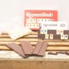 Classic Rummikub set on rustic wood table, perfect for family game night fun.