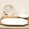 Elegant porcelain plates with floral designs on rustic wood, perfect for special occasions.