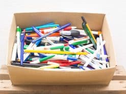 Colorful array of pens and markers in a cardboard box for creative projects and writing.