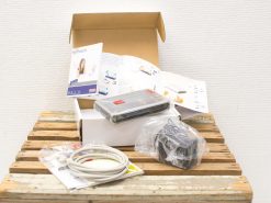 Unboxed Sitecom xDSL/Cable Router with accessories, elegantly displayed on rustic wood.