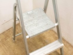 Sturdy step ladder for household tasks, featuring safety grip steps and visible signs of use.