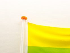 Vibrant yellow and green village flag with pole, symbolizing joy and community pride.