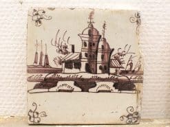 Hand-painted vintage tile featuring a coastal landscape with ships in warm brown tones.