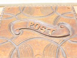 Vintage decorative mailbox in warm patina with embossed POST banner and intricate design.