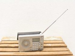 Vintage Grundig portable radio with sleek design, digital display, and foldable antenna for superior reception.