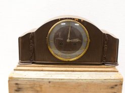 Elegant vintage wooden mantel clock with gilded accents and intricate floral carvings.