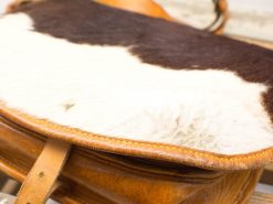 Elegant vintage leather saddle with fur accents, combining style and comfort for equestrians.