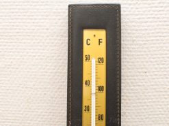 Vintage thermometer in Fahrenheit and Celsius with a yellow background, perfect for home decor.