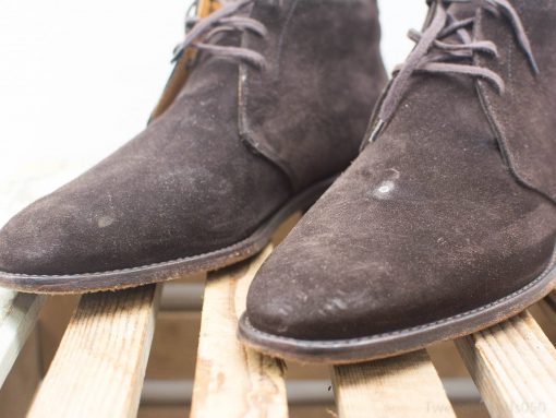 Stylish brown suede boots on rustic wood, perfect for casual and semi-formal occasions.